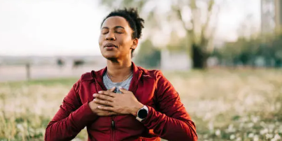 woman outside breathing with hands on her chest